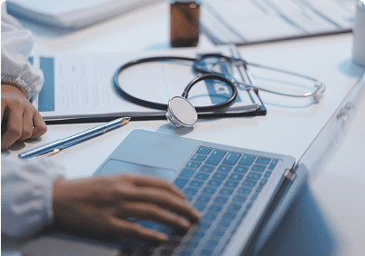 Doctor's desk with laptop and stethoscope.