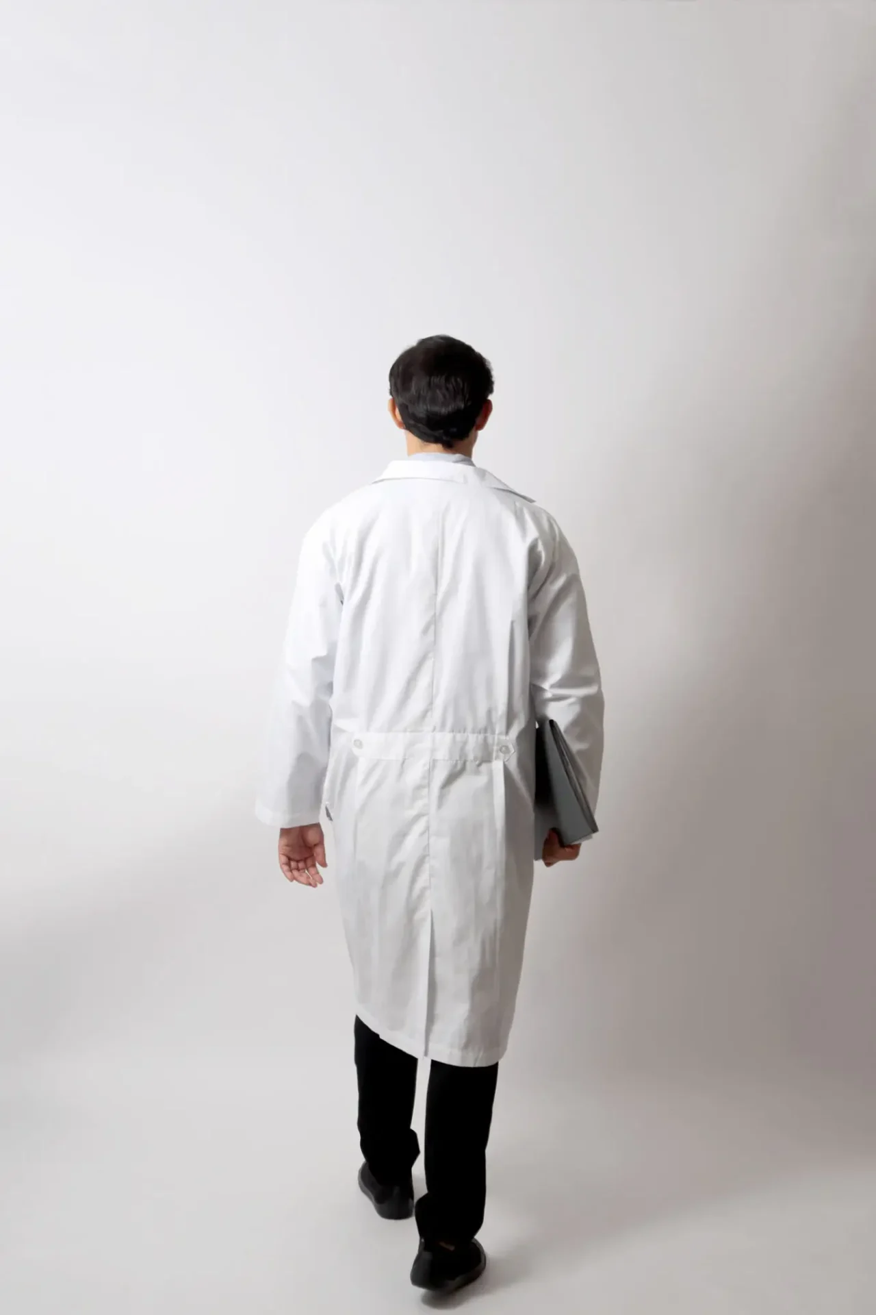 Person in white coat walking away.